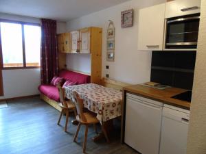 een kleine keuken met een tafel en een bank bij Résidence Melezets - Studio pour 4 Personnes 234 in Modane