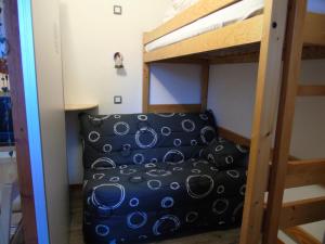 een slaapkamer met een stapelbed en een bank bij Résidence Melezets - Studio pour 4 Personnes 234 in Modane