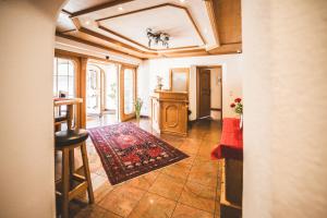 a hallway with a living room with a table and a rug at Pension Sonnenheim in Schönberg im Stubaital