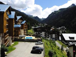 una città con auto parcheggiate in un parcheggio con montagne di Duplex 7 pers. proche des pistes 70563 a Modane