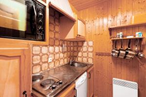 una pequeña cocina con fregadero y microondas en Chalet le Séchet - Maeva Particuliers - 2 Pièces 4 personnes Confort 140615, en Bellentre