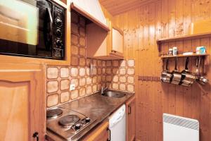 eine kleine Küche mit einer Spüle und einer Mikrowelle in der Unterkunft Chalet le Séchet - Maeva Particuliers - 2 Pièces 4 personnes Confort 140615 in Bellentre