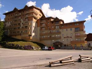 un grande edificio con un'auto parcheggiata di fronte di Résidence Cheval Blanc - 3 Pièces pour 6 Personnes 654 a Modane