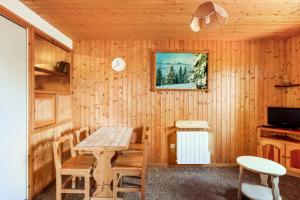 a dining room with a wooden table and chairs at Chalet le Séchet - maeva Home - 2 Pièces 4 personnes Confort MAE-0619 in Bellentre