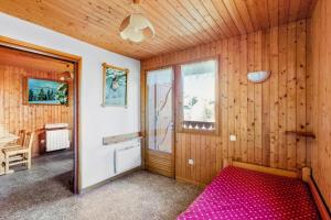 um quarto com uma cama num quarto de madeira em Chalet le Séchet - Maeva Particuliers - 2 Pièces 4 personnes Confort 140619 em Bellentre