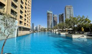 a large swimming pool in a city with tall buildings at Fashion avenue-Formerly The Address Dubai Mall residence - Downtown in Dubai