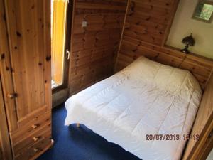 a bedroom with a white bed in a wooden room at Appartement 6 pers. avec vue montagne - 3 pièces 5 personnes MAE-0672 in Saint-Sorlin-dʼArves