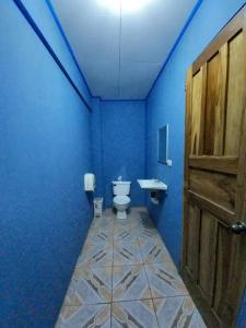 een blauwe badkamer met een toilet en een wastafel bij Cabinas Centro Social Volio #6 in Talamanca
