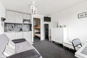 ein Wohnzimmer mit einem Bett und einer Küche in der Unterkunft Studio 4 pers. pied des pistes - maeva Home - Studio moderne 4 personnes au pied des pistes - Sélection - Super Home MAE-3345 in Morzine
