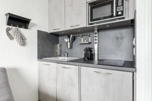 a kitchen with a sink and a microwave at Studio 4 pers. pied des pistes - Maeva Particuliers 71408 in Morzine