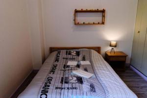 een slaapkamer met een bed met een krant erop bij Gîte de France Gîte ecole 3 épis - Gîte de France 4 personnes 434 in Soursac