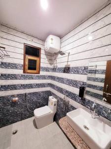 y baño con aseo blanco y lavamanos. en Utopiá 3BHK Entire Luxury Apartment In Noida 63, en Noida