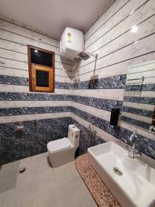 y baño con aseo y lavamanos. en Utopiá 3BHK Entire Luxury Apartment In Noida 63, en Noida