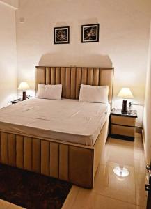 1 dormitorio con 1 cama grande y 2 mesitas de noche en Utopiá 3BHK Entire Luxury Apartment In Noida 63, en Noida