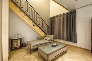 a living room with a couch and a staircase at Raffine Hotel in Gangneung