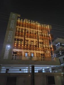 un gran edificio con luces encendidas por la noche en Utopiá 3BHK Entire Luxury Apartment In Noida 63, en Noida