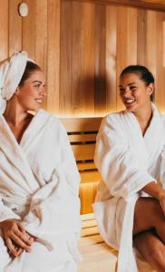 two women in white towels sitting in a room at Experience OCEAN VIEW Rooms in The Heart Of Manila, Enjoy FREE ACCESS To The POOL, SAUNA, PLUS MASSAGE PROMO In Prime Location Near The US Embassy, NAIA, Makati, BGC, Mall of Asia, And Chinatown This Is A Limited-Time Offer, Book Now in Manila