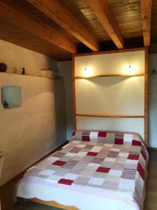 Un dormitorio con una cama con una manta a cuadros. en Gîte de France La gloire 3 épis - Gîte de France 4 personnes MAE-6514, en Noual