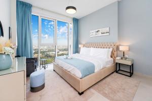 a bedroom with a large bed and large windows at FAM Living - 2 Bedroom Home close to Dubai Frame in Dubai