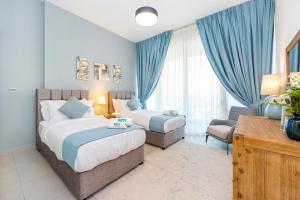 a hotel room with two beds and a chair at FAM Living - 2 Bedroom Home close to Dubai Frame in Dubai