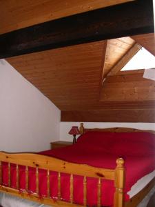 a bedroom with a wooden bed with red sheets at Appartement à Belle Plagne à 150m des pistes 70902 in La Plagne