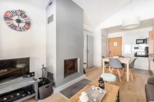 a living room with a fireplace and a clock on the wall at Résidence Les terrasses d'Eos - maeva Home - 3 Pièces 6 Personnes - Sélect 67 in Flaine