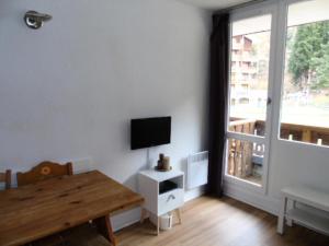 a living room with a table and a tv on a wall at Résidence Thabor - Studio pour 3 Personnes 894 in Modane