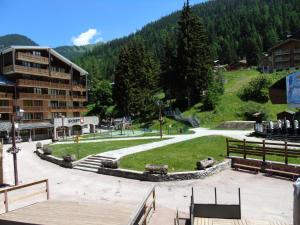 a park in a resort with a building and trees at Résidence Thabor - Studio pour 3 Personnes 894 in Modane