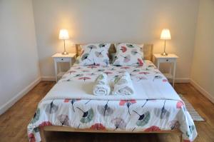 Un dormitorio con una cama con dos lámparas sobre dos mesas. en Gîte de France Aux deux mésanges 4 épis - Gîte de France 10 personnes MAE-6364, en Sainte-Fortunade 18 fotos más