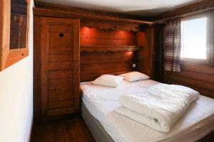 Schlafzimmer mit einem Bett mit weißer Bettwäsche und Kissen in der Unterkunft Résidence La Ginabelle - maeva Home - 4 Pièces 6 Personnes Sélection 71 in Chamonix-Mont-Blanc