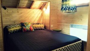 a bedroom with a bed in a room with wooden walls at Gîte de France La cabane du causse 1 étoile - Gîte de France 2 personnes MAE-6394 in Lissac-sur-Couze