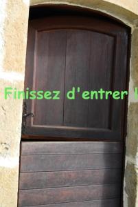 une porte de garage en bois avec les mots finsez un ingénieur dans l'établissement Gîte de France à Saillac 3 épis - Gîte de France 4 personnes 444, à Saillac