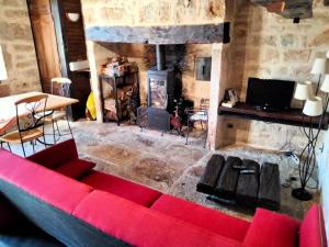 - un salon avec un canapé rouge et une cheminée dans l'établissement Gîte de France à Saillac 3 épis - Gîte de France 4 personnes 444, à Saillac