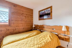 2 Betten in einem Schlafzimmer mit Holzwänden in der Unterkunft Résidence Les Fermes du Soleil - maeva Home - 3 Pièces 6 Personnes Sélection MAE-4102 in Les Carroz d'Araches + 19 Fotos