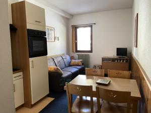 ein Wohnzimmer mit einem Sofa und einem Tisch in der Unterkunft LE CHALET - Piscine - Studio pour 4 Personnes 704 in Gourette