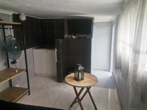 a small room with a table and a kitchen at Pra la Vue in Durban