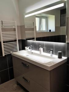 ein Badezimmer mit einem weißen Waschbecken und einem Spiegel in der Unterkunft Gîte de France Au bord de l'eau 3 épis - Gîte de France 6 personnes 674 in Aubazines
