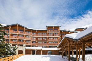 a large hotel with snow on the ground at Résidence Les Crêts - maeva Home - 3 Pièces 6 Personnes - Confort MAE-1026 in Les Allues