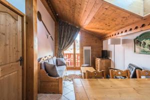 ein Wohnzimmer mit Tisch und Stühlen in der Unterkunft Résidence Les Fermes du Soleil - maeva Home - Appartement 4 pièces 7 personnes Selection MAE-0493 in Les Carroz d'Araches