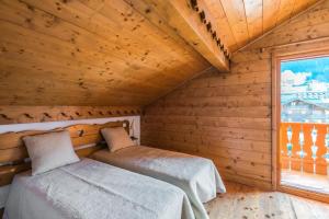 2 Betten in einem Holzzimmer mit Fenster in der Unterkunft Résidence Les Fermes du Soleil - maeva Home - Appartement 4 pièces 7 personnes Selection MAE-0493 in Les Carroz d'Araches + 21 Fotos