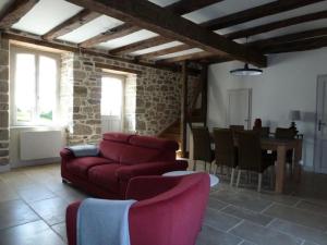 Gîte de France Chez le fustier 4 épis - Gîte de France 6 personnes MAE-8924 في Albussac: غرفة معيشة مع أريكة حمراء وطاولة