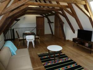 Gîte de France Chez le fustier 4 épis - Gîte de France 6 personnes MAE-8924 في Albussac: غرفة معيشة بها أريكة وطاولة