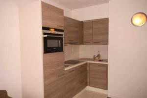 una cocina con armarios de madera y fregadero en Résidence EURONEIGE - Studio pour 6 Personnes 974, en Gourette