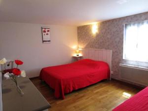 a bedroom with a red bed and a window at Gîte de France Gîte de la barbacane 3 épis - Gîte de France 5 personnes MAE-8884 in Curemonte