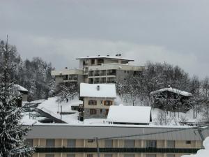 un edificio cubierto de nieve con techos nevados en Résidence CHRISTIANIA - Studio pour 6 Personnes 964, en Gourette
