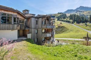 an old wooden house on a hill with a road at Résidence Sépia - maeva Home - Appartement 2 pièces 5 personnes Sélection 66 in Morzine