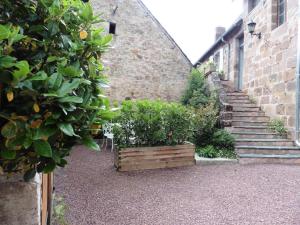 an old brick building with stairs and plants in a yard at Gîte de France Gîte la chapelle 3 épis - Gîte de France 6 personnes MAE-8904 in Saint-Solve