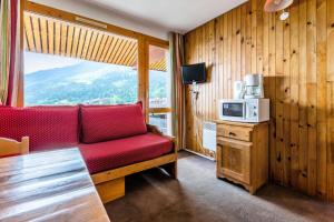 - un salon avec un canapé rouge et un four micro-ondes dans l'établissement Quartier Crève Cœur - maeva Home - Studio 2 personnes Confort MAE-2092, à Valmorel 17 autres photos