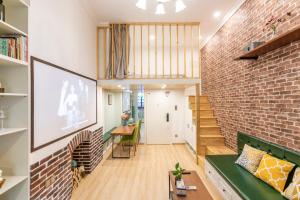 a room with a brick wall and a green couch at Shanghai Hills&XING 1881 Homestay in Shanghai