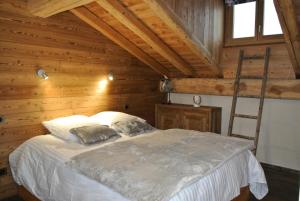 ein Schlafzimmer mit einem Bett in einer Holzhütte in der Unterkunft Maison 7 pièces 12 personnes centre station proche pistes 79925 in Bessans
